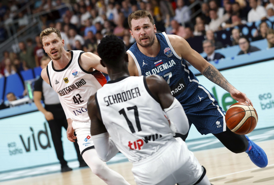 Luka Dončić u napadu, dok ga juri Andreas Obst, a ispred njega postavlja nemački kapiten Denis Šreder